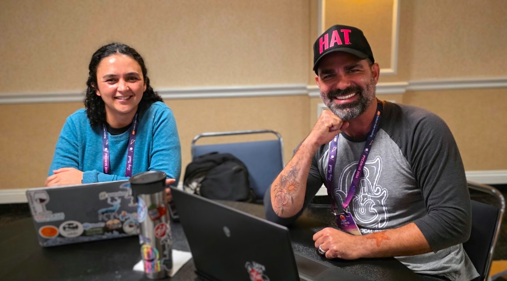 Three pyOpenSci community members smiling together at an outdoor patio during PyCon US 2026 in Long Beach.